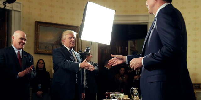 U.S. President Donald Trump greets Director of the FBI James Comey as Director of the Secret Service Joseph Clancy (L) watches during the Inaugural Law Enforcement Officers and First Responders Reception in the Blue Room of the White House in Washington, U.S., January 22, 2017. REUTERS/Joshua Roberts TPX IMAGES OF THE DAY - RTSWV9G