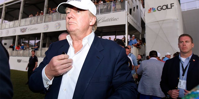March 6, 2016: Donald Trump walks onto the 18th green for the awards ceremony following the final round at TPC Blue Monster at Trump National Doral.