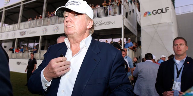 March 6, 2016: Donald Trump walks onto the 18th green for the awards ceremony following the final round at TPC Blue Monster at Trump National Doral.