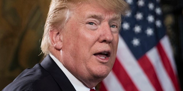President Donald Trump turns to talk to the gathered media during a Christmas Eve video teleconference with members of the mIlitary at his Mar-a-Lago estate in Palm Beach, Fla., Sunday, Dec. 24, 2017. (AP Photo/Carolyn Kaster)