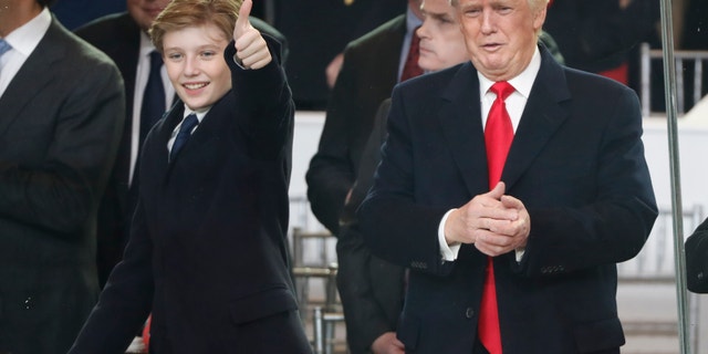 President Donald Trump, right, and his son Barron react as they view the 58th Presidential Inauguration parade for Donald Trump in Washington. Friday, Jan. 20, 2017.