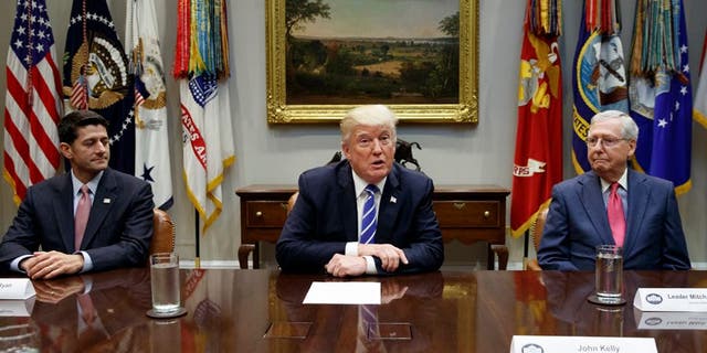 President Trump sits at the White House with House Speaker Paul Ryan and Senate Majority Leader Mitch McConnell to talk taxes last month. The tax bill passed both the House and the Senate on Tuesday.
