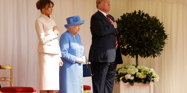 First Lady Melania Trump, left, Queen Elizabeth II, center, and President Trump, right, stand for the National Anthem at Windsor Castle.