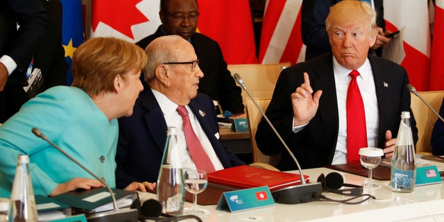 U.S. President Donald Trump talks to German Chancellor Angela Merkel (L) and Tunisia's President Beji Caid Essebsi (2-L) at the G7 Summit expanded session in Taormina, Sicily, Italy May 27, 2017. REUTERS/Jonathan Ernst - RTX37U3O
