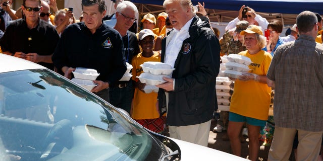 Trump and North Carolina Gov. Roy Cooper hand out packaged meals in New Bern.