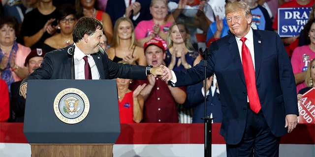 President Donald Trump, right, shakes hands with 12th Congressional District Republican candidate Troy Balderson, left, during a rally on Saturday in Lewis Center, Ohio.