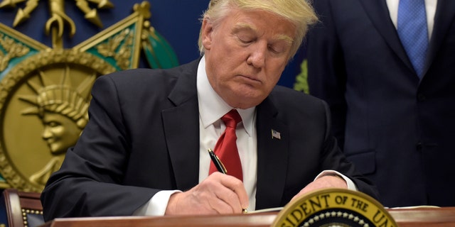 President Donald Trump signs an executive order on extreme vetting during an event at the Pentagon in Washington, Friday, Jan. 27, 2017. (AP Photo/Susan Walsh)
