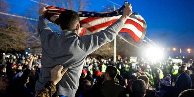 A Donald Trump supporter waves an American flag at a Trump campaign rally in Bethpage, N.Y., April 6, 2016.