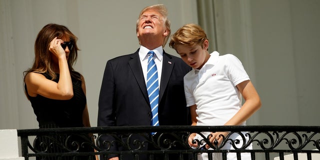 Without his protective glasses on, U.S. President Donald Trump looks up towards the solar eclipse while viewing with his wife Melania and son Barron at the White House in Washington, U.S., August 21, 2017. REUTERS/Kevin Lamarque TPX IMAGES OF THE DAY - RTS1CPZ8