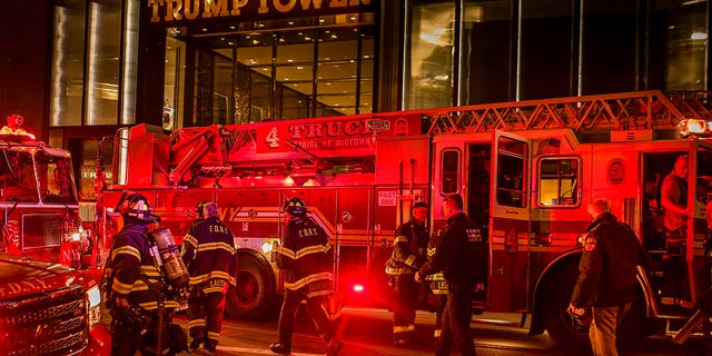 Firefighters work outside Trump Tower in New York City, April 7, 2018.