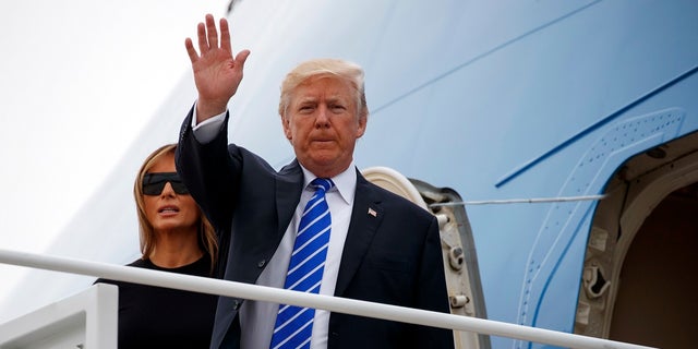 President Donald Trump waves as he boards Air Force One with first lady Melania Trump for a trip to Poland and Germany, Wednesday, July 5, 2017, at Andrews Air Force Base, Md.