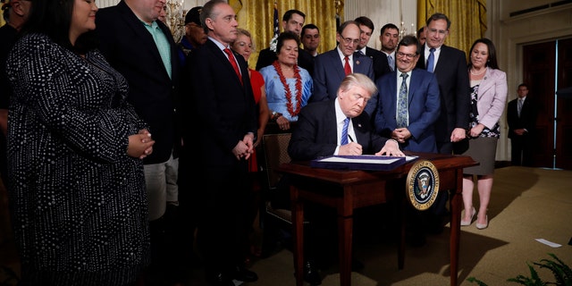 U.S. President Donald Trump signs the âVA Accountability Actâ during a signing ceremony in the East Room of the White House in Washington, U.S., June 23, 2017. REUTERS/Jonathan Ernst - RTS18DQJ
