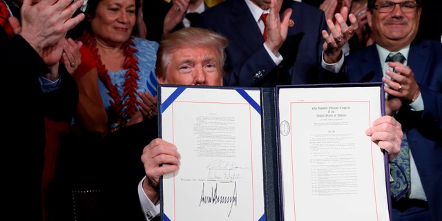 U.S. President Donald Trump displays the âVA Accountability Actâ during a signing ceremony in the East Room of the White House in Washington, U.S., June 23, 2017. REUTERS/Jonathan Ernst - RTS18DQB