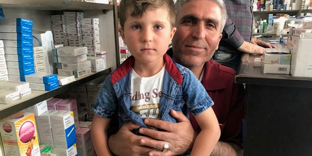 Rezgar Ramadan holding his five-year-old son, Trump, who was renamed after the 2016 presidential election.