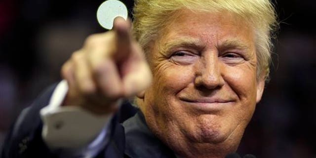 Republican presidential candidate Donald Trump points at a supporter during a rally Friday, Feb. 12, 2016, in Tampa, Fla. (AP Photo/Chris O'Meara)