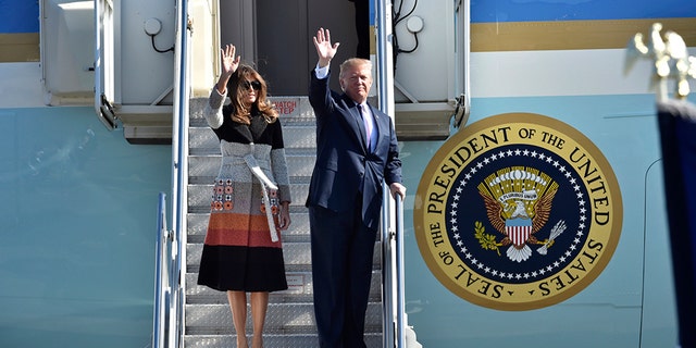 President Donald Trump and first lady Melania Trump wave from the steps of Air Force One.