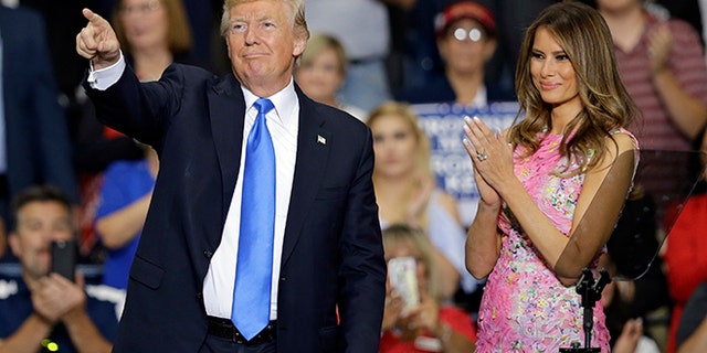President Donald Trump points to his supporters as first lady Melania Trump watches after speaking at the Covelli Centre, Tuesday, July 25, 2017, in Youngstown, Ohio. (AP Photo/Tony Dejak)