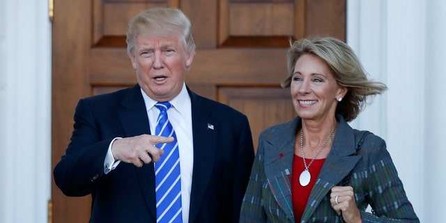 President Trump and Education Secretary Betsy DeVos are seen at Trump National Golf Club Bedminster in Bedminster, N.J., prior to Trump taking office, in an undated photo. (Associated Press)