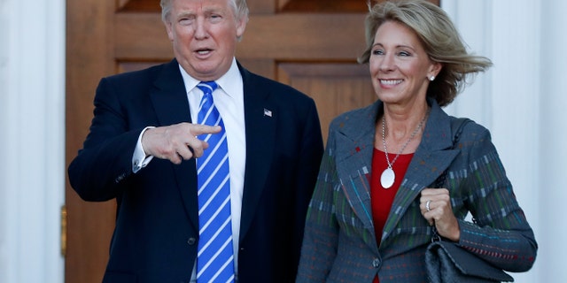 President Trump and Education Secretary Betsy DeVos are seen at Trump National Golf Club Bedminster in Bedminster, N.J., prior to Trump taking office, in an undated photo. (Associated Press)