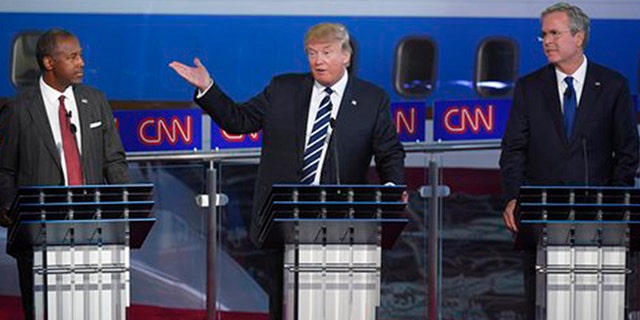 Republican presidential candidate, businessman Donald Trump, center, speaks as Ben Carson, left, and Jeb Bush, look on during the CNN Republican presidential debate at the Ronald Reagan Presidential Library and Museum on Wednesday, Sept. 16, 2015, in Simi Valley, Calif. (AP Photo/Mark J. Terrill)