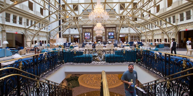 Workers move around inside the Trump International Hotel during it's 'soft-opening' in downtown Washington, Monday, Sept. 12, 2016 in Washington
