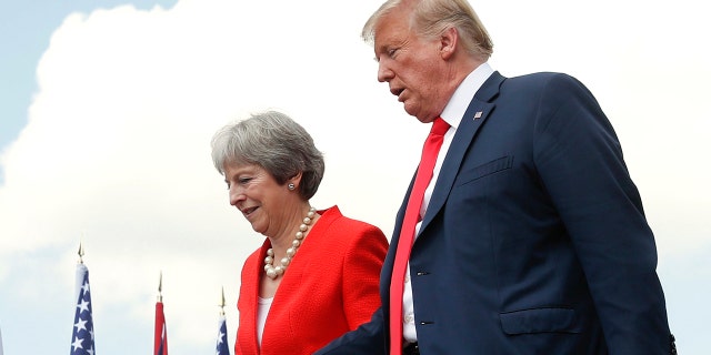 President Donald Trump and British Prime Minister Theresa May hold hands at the conclusion of their joint news conference at Chequers, in Buckinghamshire, England, Friday, July 13, 2018.