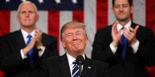 FILE - In this Feb. 28, 2017, file photo, President Donald Trump addresses a joint session of Congress on Capitol Hill in Washington, as Vice President Mike Pence and House Speaker Paul Ryan of Wis., applaud. President Trumpâs first state of the union speech will carry more suspense than most. (Jim Lo Scalzo/Pool Image via AP, File)
