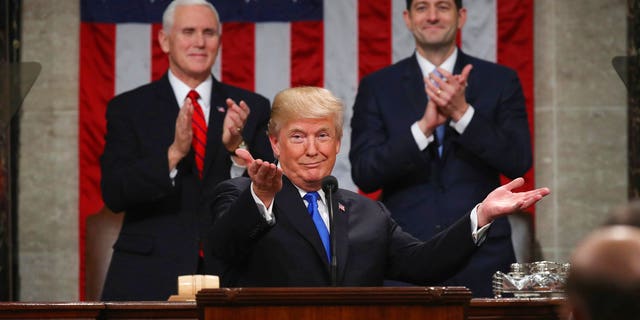 President Donald Trump gestures as delivers his first State of the Union address in the House chamber of the U.S. Capitol to a joint session of Congress Tuesday, Jan. 30, 2018 in Washington, as Vice President Mike Pence and House Speaker Paul Ryan applaud. (Win McNamee/Pool via AP)