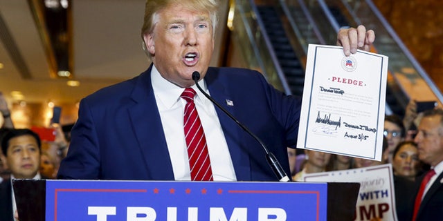 Sept. 3, 2015: U.S. presidential hopeful Donald Trump holds up a signed pledge during a press availability at Trump Tower in Manhattan, New York. (Reuters)