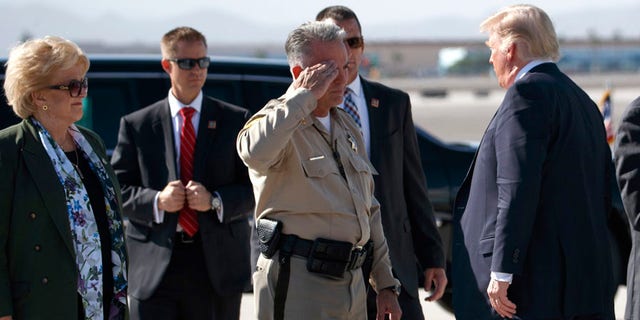 Clark County Sheriff Joseph Lombardo salutes President Donald Trump after he arrived at Las Vegas McCarran International Airport to meet with victims and first responders of the mass shooting.