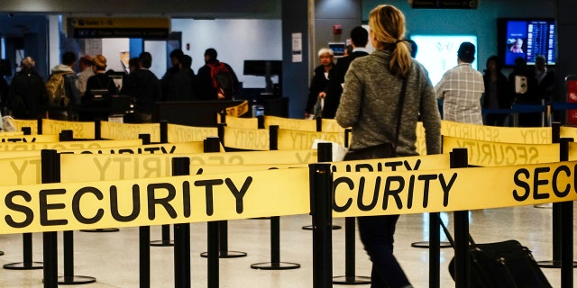 Passengers make their way in a security checkpoint at the International JFK airport in New York October 11, 2014.