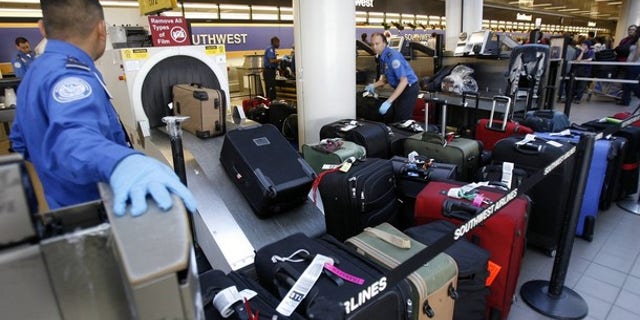 Transportation Security Administration officers put passengers' suitcases through an X-ray machine at Los Angeles International Airport Dec. 29. (Reuters Photo)
