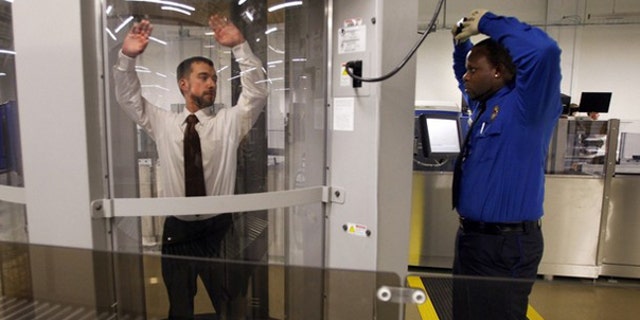 FILE: Undated: Transportation Security Administration staffers at the agency's Washington, D.C., training facility demonstrate a full-body scanning machine.