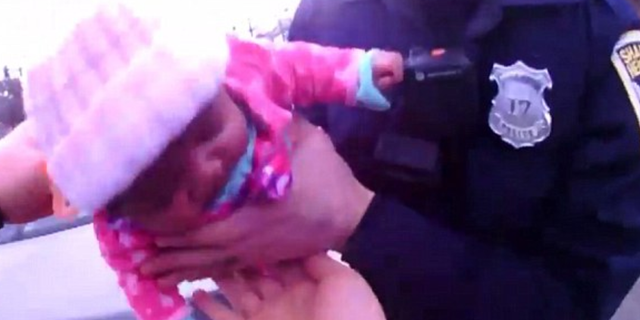 An image captured from police video shows 2-month-old Tyra Pruitte being assisted by police officers in Shaker Heights, Ohio.