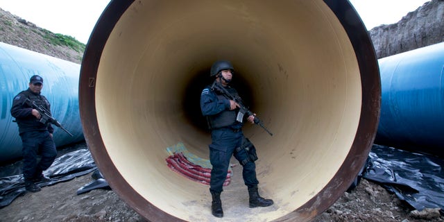 Federal police guard a drainage pipe outside of the Altiplano maximum security prison Sunday, July 12, 2015.