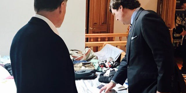 Fox News' Tucker Carlson looks over items belonging to Otto Warmbier as father Fred Warmbier looks on