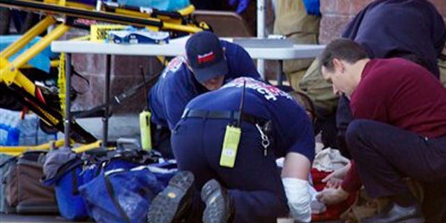 Emergency personnel attend to a shooting victim outside a shopping center in Tucson, Ariz., on Jan. 8.