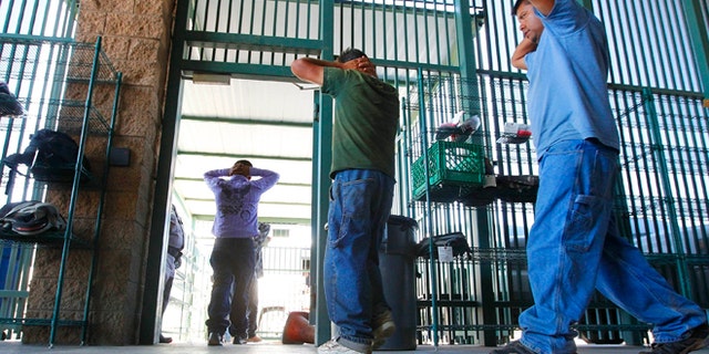 In this Aug. 9, 2012, file photo, suspected illegal immigrants are transferred out of the holding area after being processed at the Tucson Sector of the U.S. Customs and Border Protection headquarters in Tucson, Ariz.