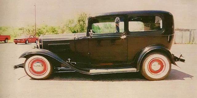 The black coupe has a red interior, undercoating, grille and wheels.
