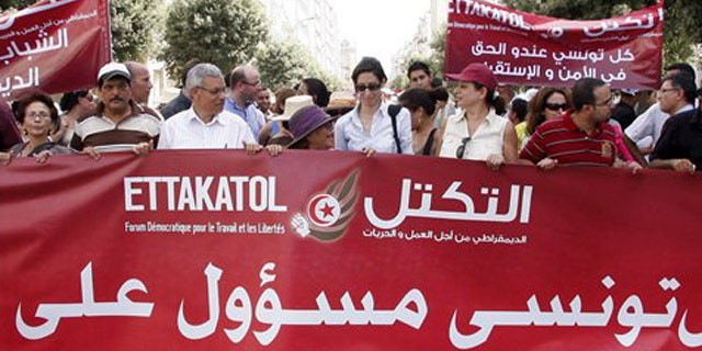 Demonstrators from a dozen of political parties hold a banner reading "Each Tunisian is responsible for his country" during a march against violence in Tunis , Thursday, July 21, 2011 as Tunisia prepares for landmark Oct. 23 elections for a body meant to write a new constitution. Banner at right behind reads: Any Tunisian has the right to security.
