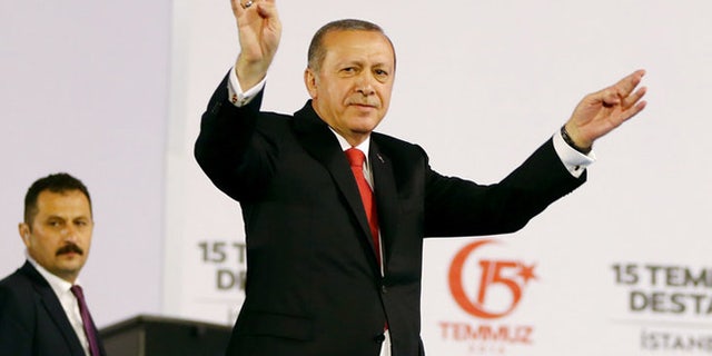 Turkey's President Recep Tayyip Erdogan accompanied by his wife Emine waves to his supporters as he arrives to commemorate the one year anniversary of the July 15, 2016 failed coup attempt, in Istanbul, Saturday, July 15, 2017. Turkey commemorates the first anniversary of the July 15 failed military attempt to overthrow Erdogan, with a series of events honouring some 250 people, who were killed across Turkey while trying to oppose coup-plotters. (Presidency Press Service via AP, Pool)