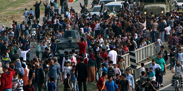 Oct. 29, 2014: Cheering local people surround a group of Iraqi Kurdish Peshmerga troops arrived in Nusaybin, Mardin in southeastern Turkey. The Peshmergas are on their way to Syria to help Syrian Kurds fighting Islamic State extremists in the embattled border town of Kobani.