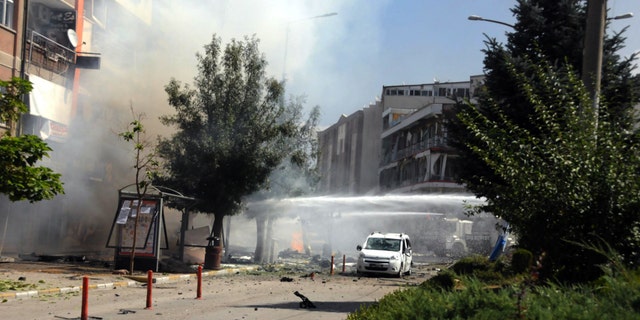 Firefighters work to extinguish a fire after a car bomb attack in the city center of Van.