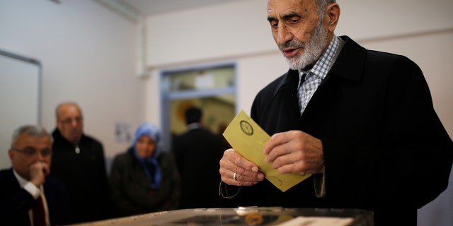 A voter prepares to cast a ballot inside a polling station in Istanbul, Sunday, April 16, 2017.