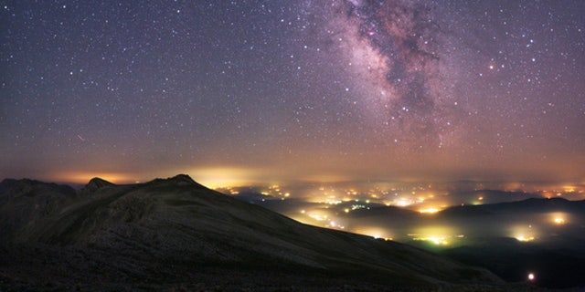 A view from the Uludag National Park in Turkey. The Milky Way stretches across the sky above the manmade pockets of hazy lights from the towns and villages below.