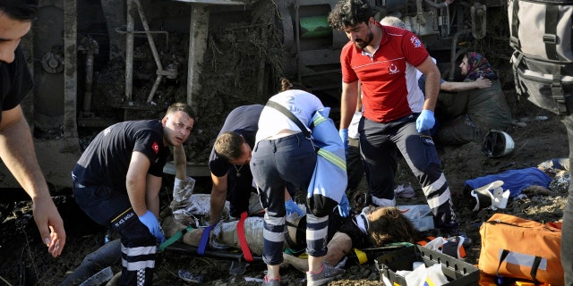 Rescue workers prepare to transport a female victim.
