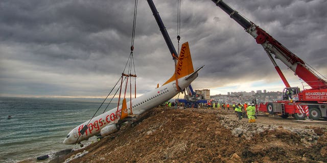 Turkish authorities used a large crane to lift a passenger plane from the side of the cliff on Thursday.
