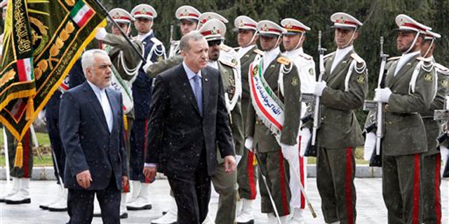 March 28, 2012: Turkish Prime Minister, Recep Tayyip Erdogan, right, is accompanied by Iranian Vice-President Mohammad Reza Rahimi, left, during an official welcoming ceremony in Tehran, Iran.