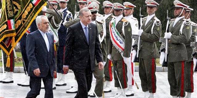 March 28, 2012: Turkish Prime Minister, Recep Tayyip Erdogan, right, is accompanied by Iranian Vice-President Mohammad Reza Rahimi, left, during an official welcoming ceremony in Tehran, Iran.