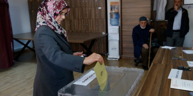 A woman casts a ballot inside a polling station in Istanbul, Sunday, April 16, 2017. Voters in Turkey were deciding Sunday on the future of their country, with polling stations opening for a historic referendum, which was called by President Recep Tayyip Erdogan, on whether to approve reforms that would concentrate power in the hands of the president. (AP Photo/Lefteris Pitarakis)